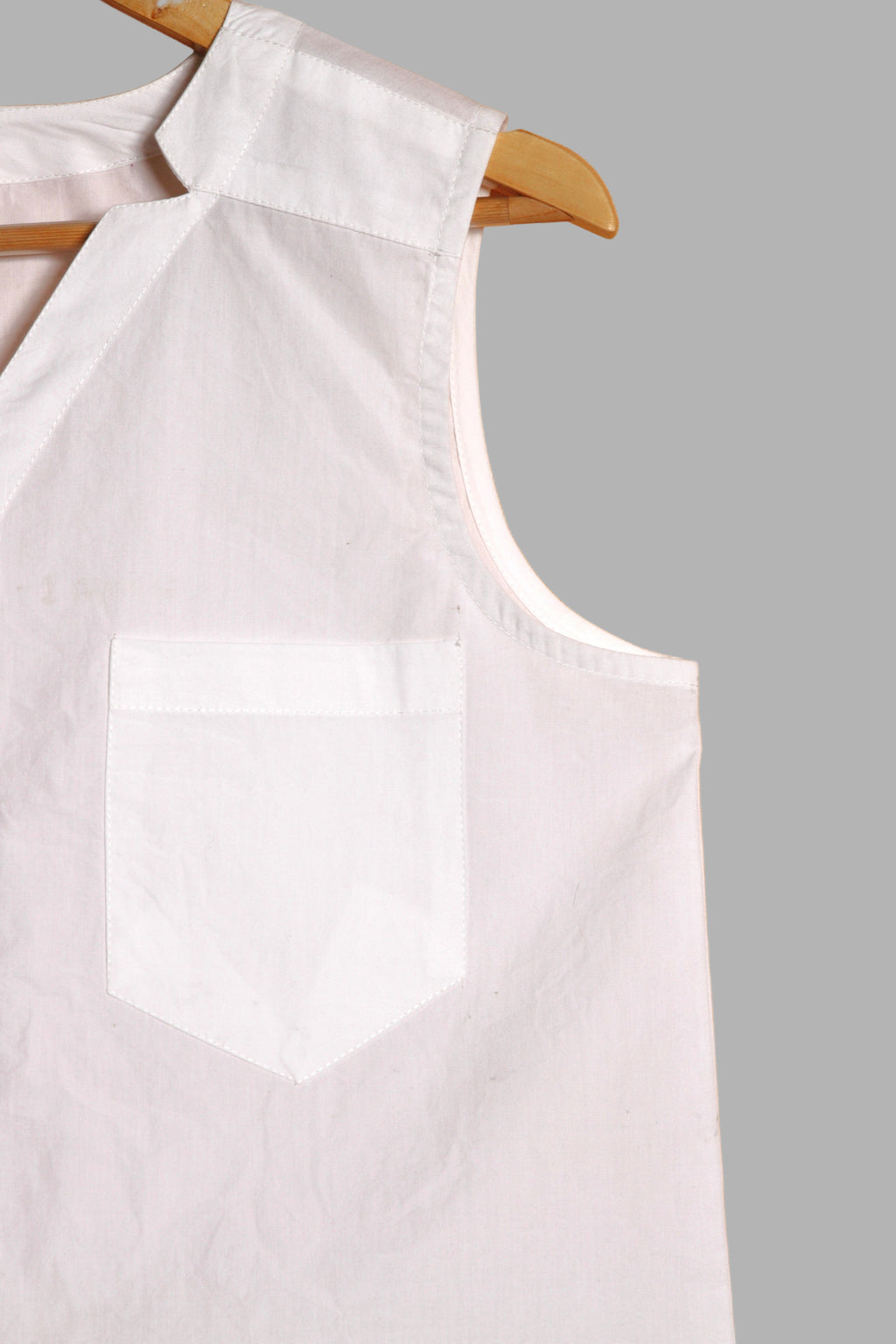Close-up of a fullblank branded white sleeveless top called KIKI-A with a plain background