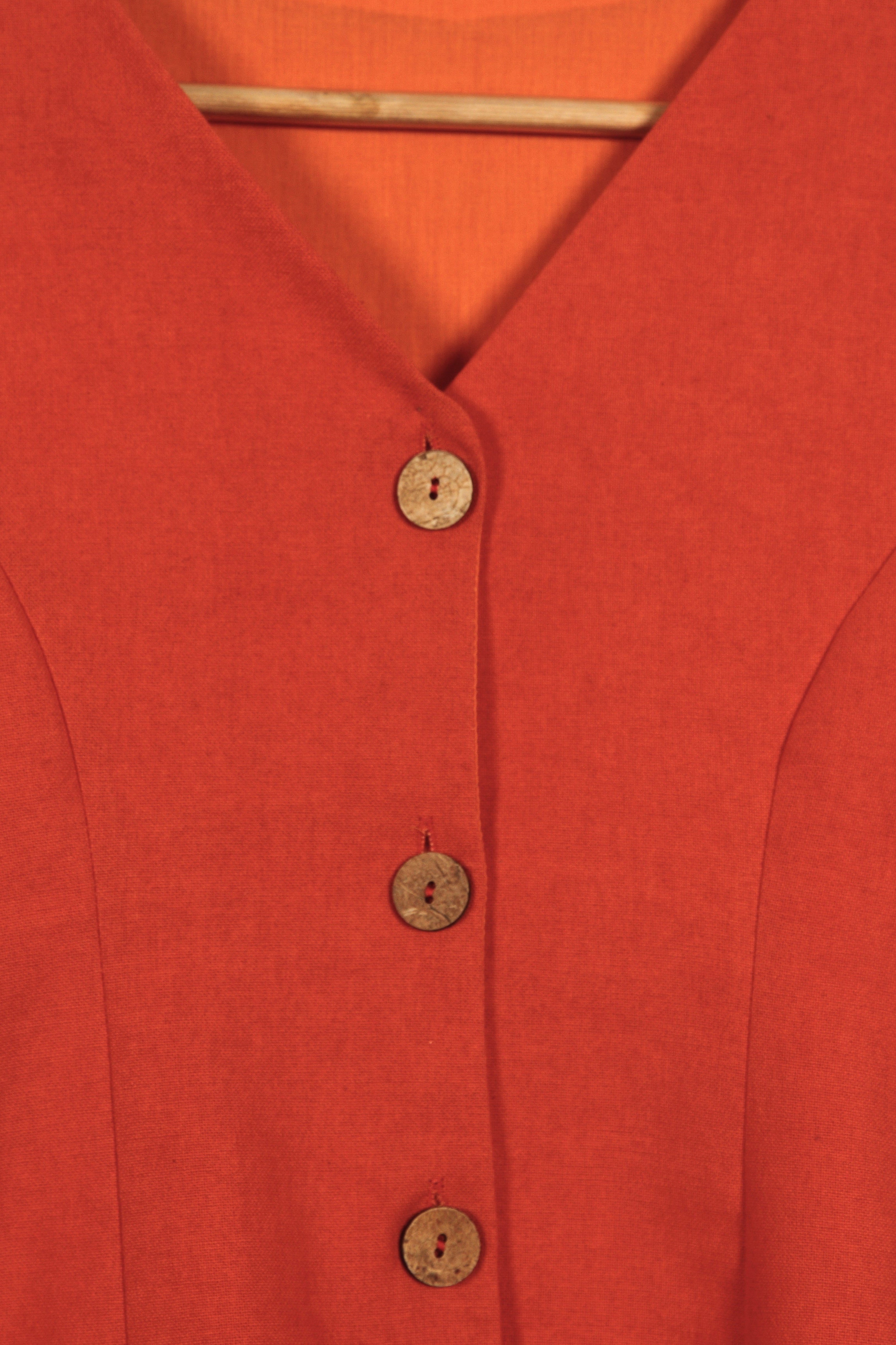 Close-up of a fullblank branded orange sleeveless top called KIRA-A with a plain background