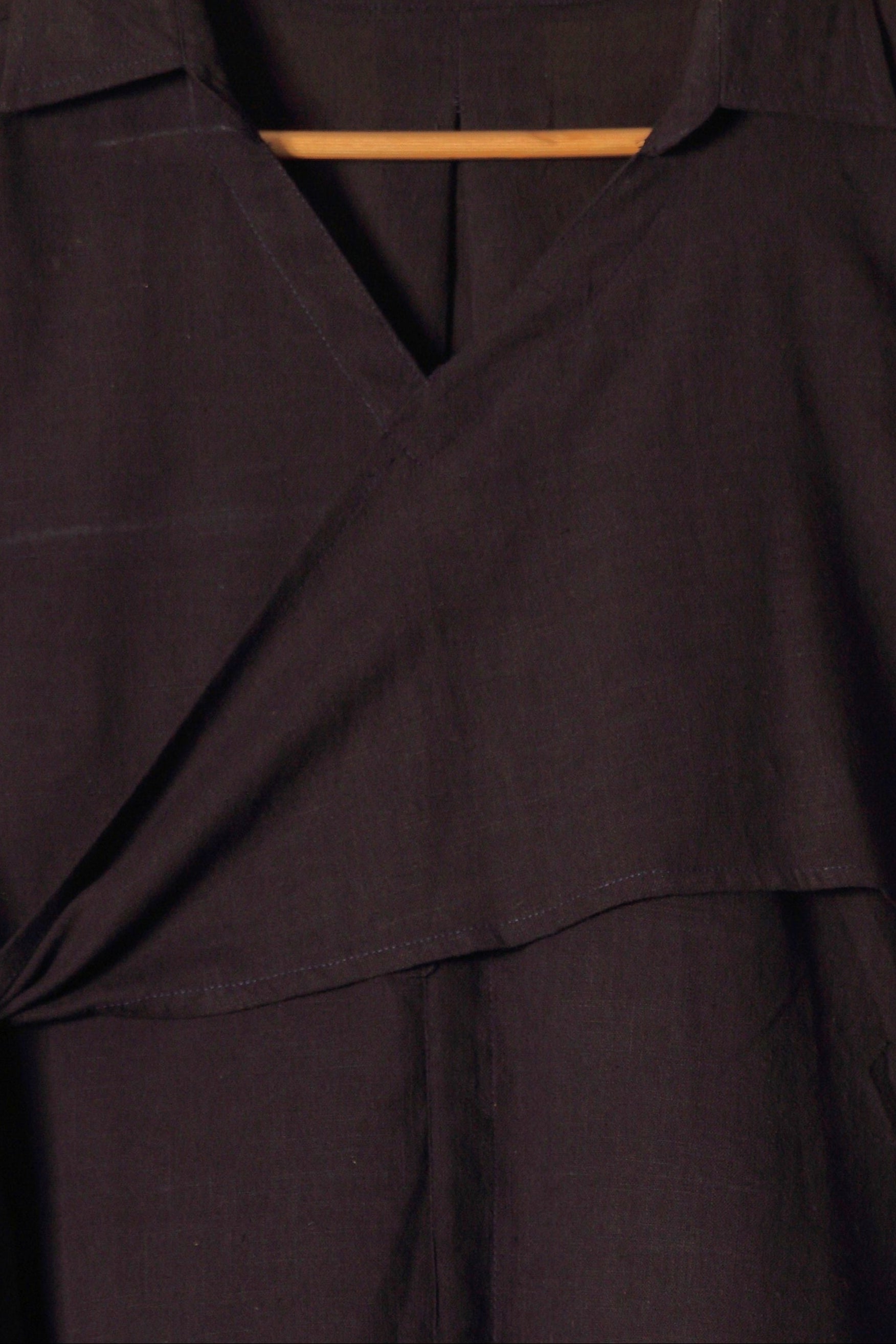 Close-up of a fullblank branded black long-sleeve shirt called MIDNIGHT MUSE-B with a plain background