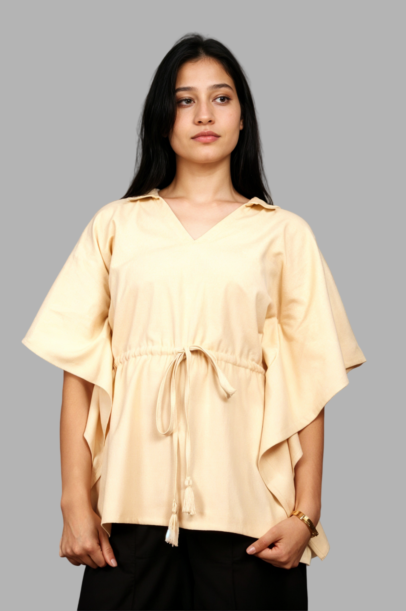 Woman wearing a fullblank branded beige kaftan called AIRA-A with a plain background