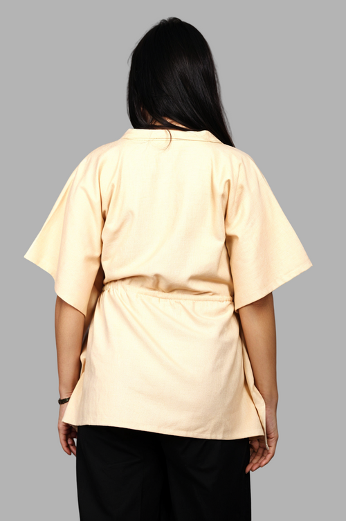 Woman wearing a fullblank branded beige kaftan called AIRA-A with a plain background