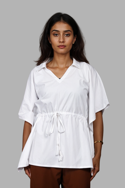 Woman wearing a fullblank branded white kaftan called AIRA-B with a plain background