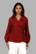 Woman wearing a fullblank branded red shirt called CLEO-A with a plain background