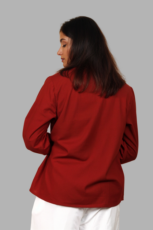 Woman wearing a fullblank branded red shirt called CLEO-A with a plain background