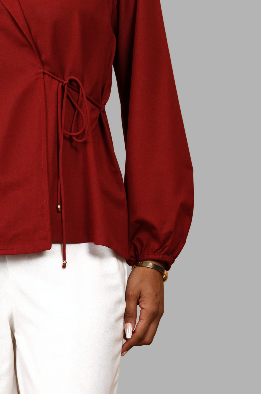 Woman wearing a fullblank branded red shirt called CLEO-A with a plain background