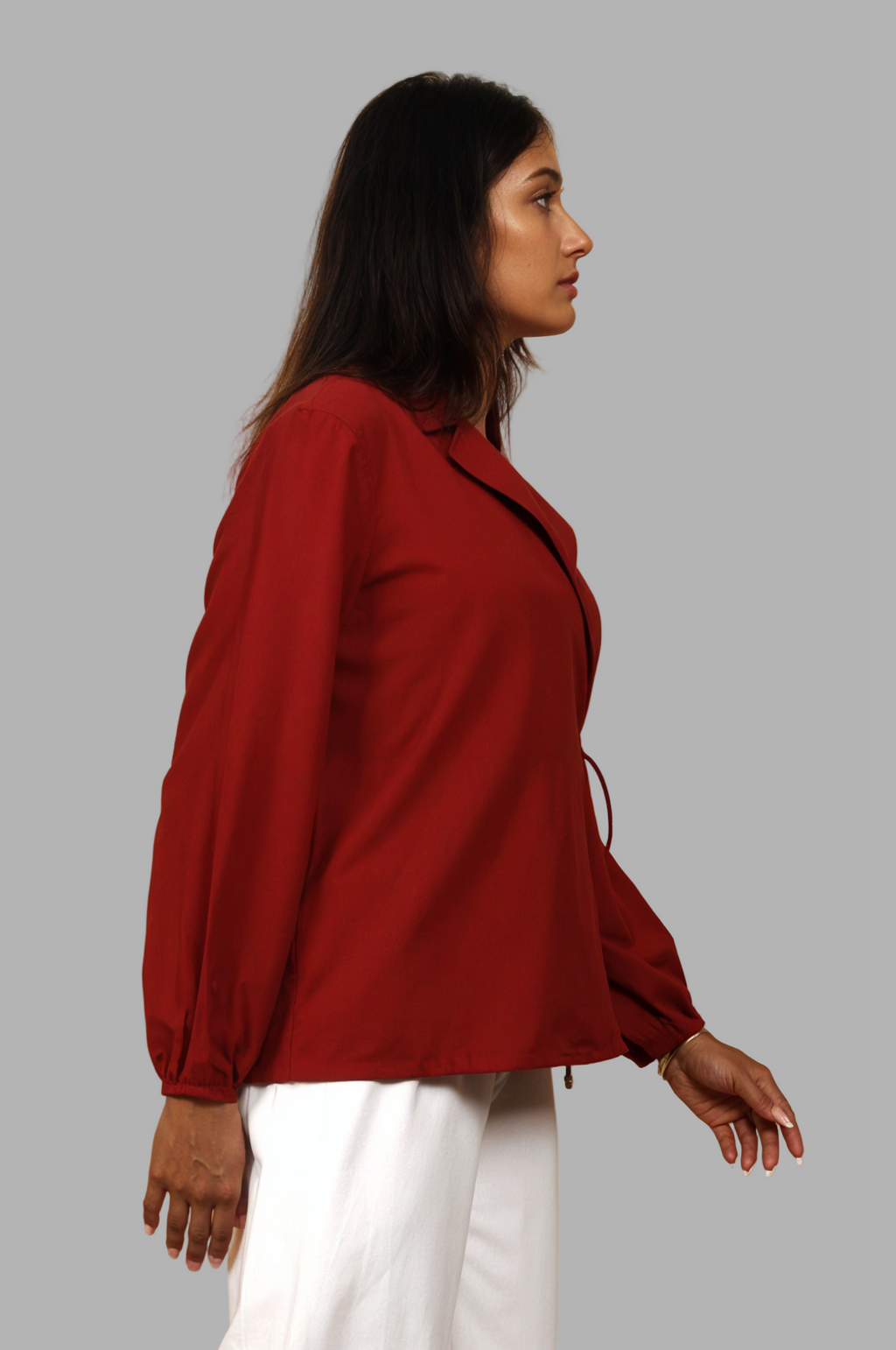 Woman wearing a fullblank branded red shirt called CLEO-A with a plain background