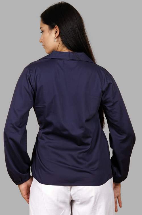 Woman wearing a fullblank branded navy blue shirt called CLEO-B with a tie detail on a plain background