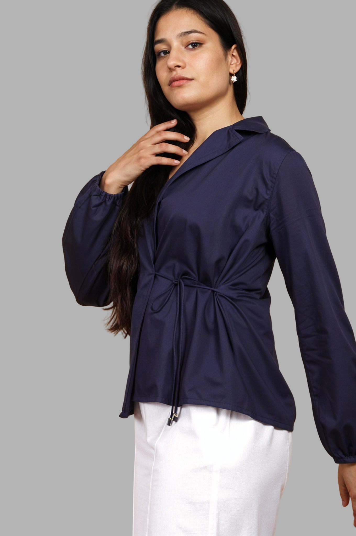 Woman wearing a fullblank branded navy blue shirt called CLEO-B with a tie detail on a plain background