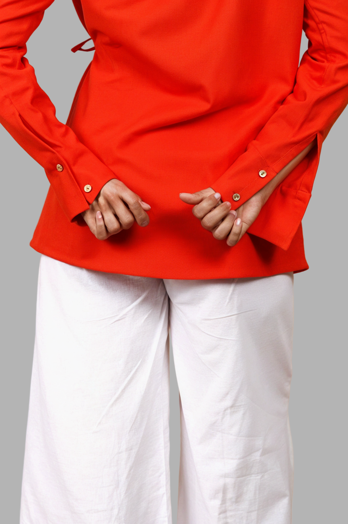 Woman wearing a fullblank branded red orange shirt called COCO-B on a plain background