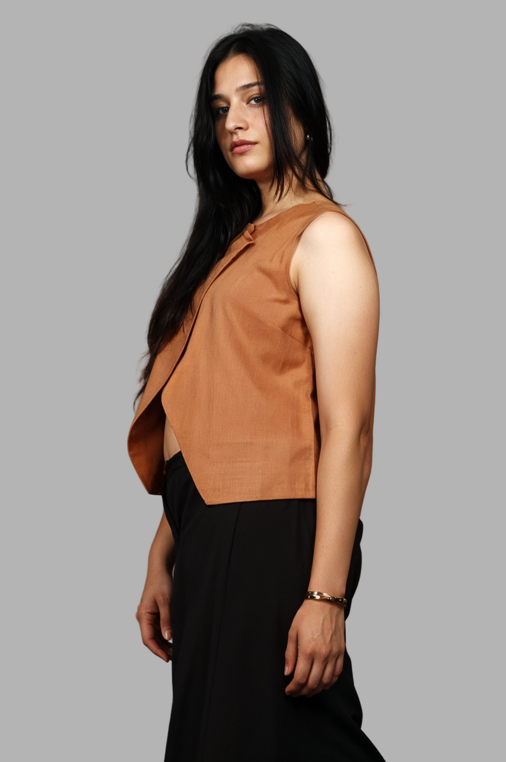 Woman wearing a fullblank branded brown sleeveless top called EIRA-A with a plain background