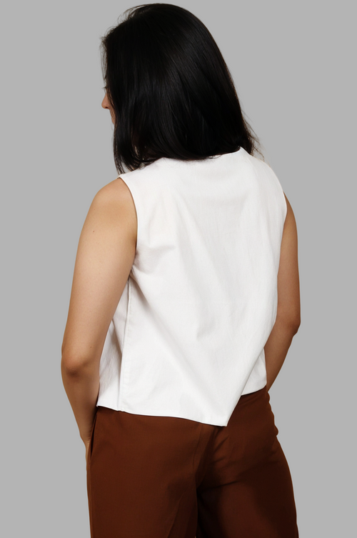 Woman wearing a fullblank branded white sleeveless top called EIRA-B with a plain background