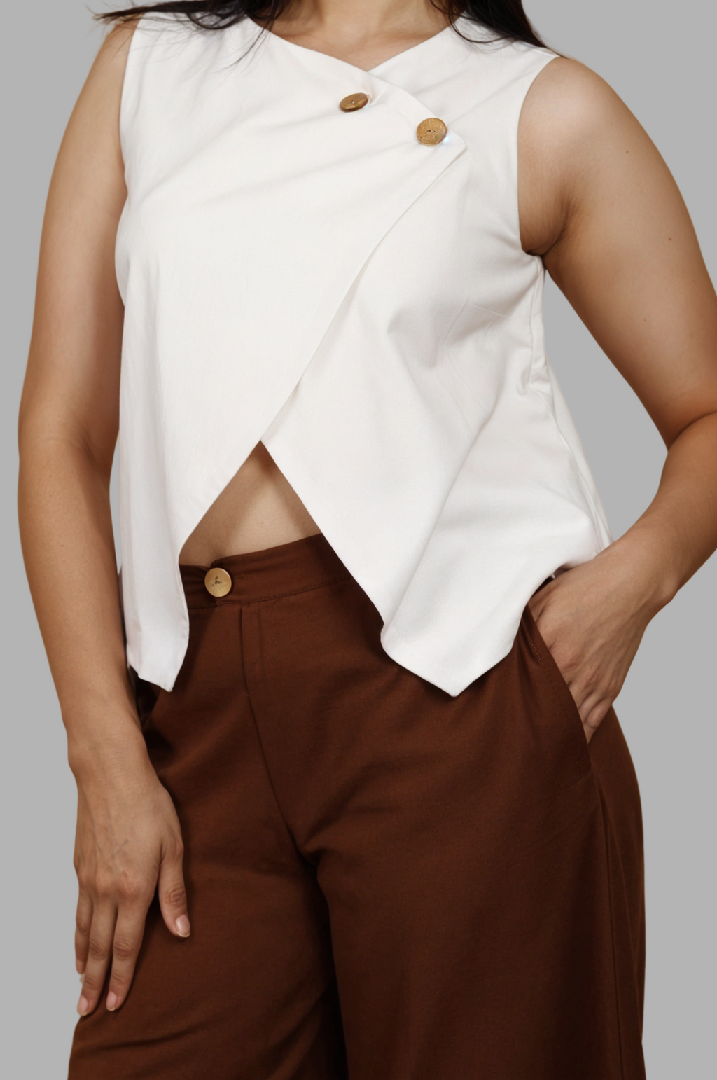 Woman wearing a fullblank branded white sleeveless top called EIRA-B with a plain background