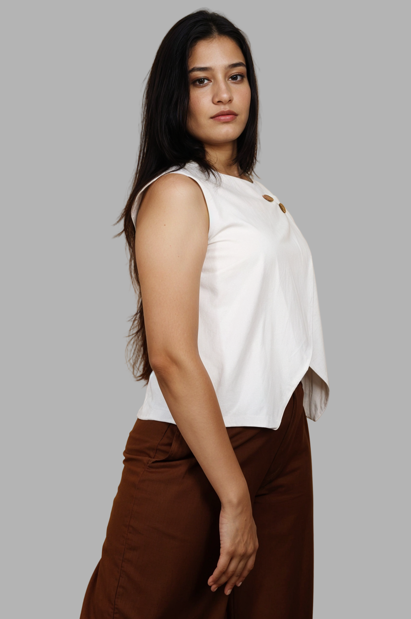 Woman wearing a fullblank branded white sleeveless top called EIRA-B with a plain background