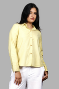 Woman wearing a fullblank branded pistachio shirt called FABLE-A with a plain background