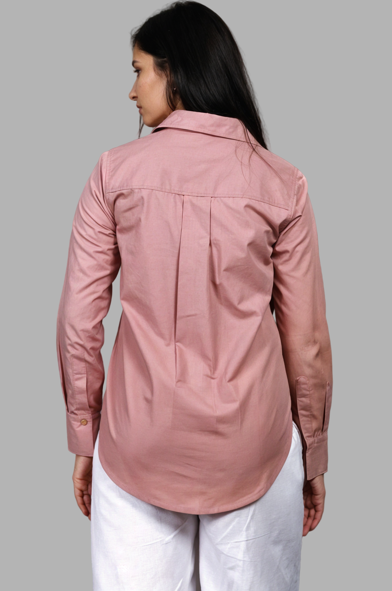 Woman wearing a fullblank branded pink shirt called FABLE-B with a plain background