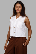 Woman wearing a fullblank branded white sleeveless top called KIKI-A with a plain background