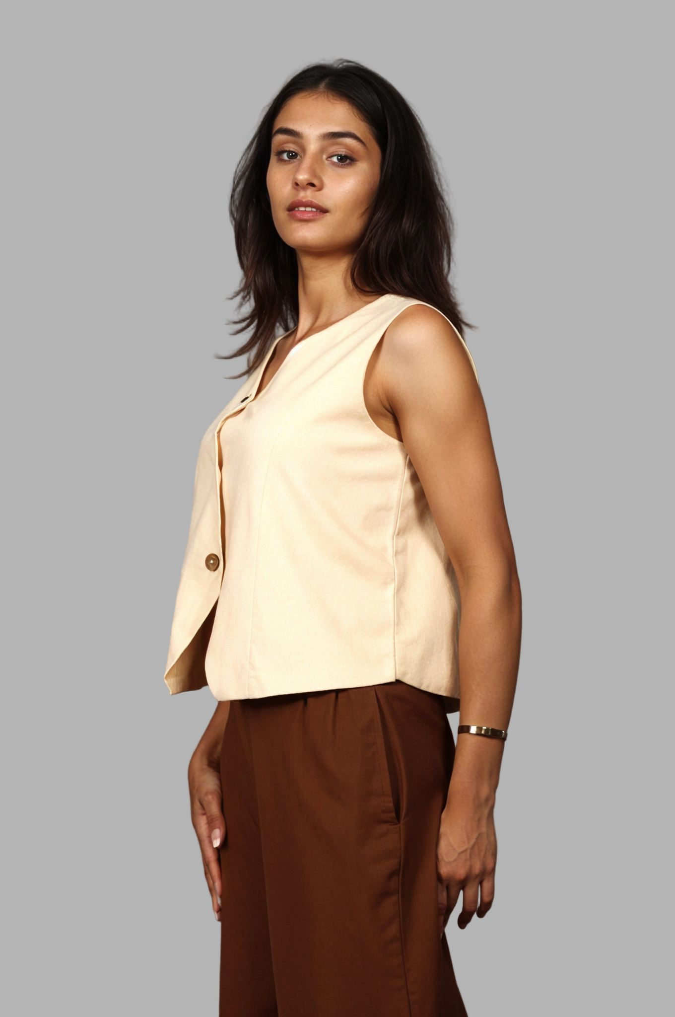 Woman wearing a fullblank branded beige vest called KIRA-B with a plain background