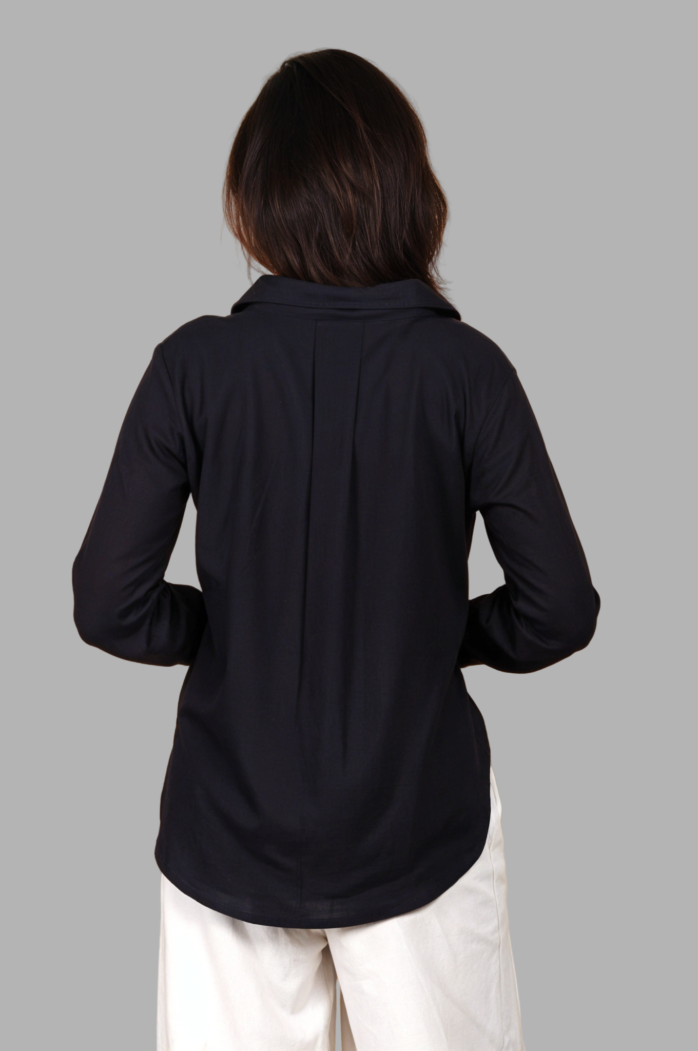Woman wearing a fullblank branded black long-sleeve shirt called MIDNIGHT MUSE-B with a plain background