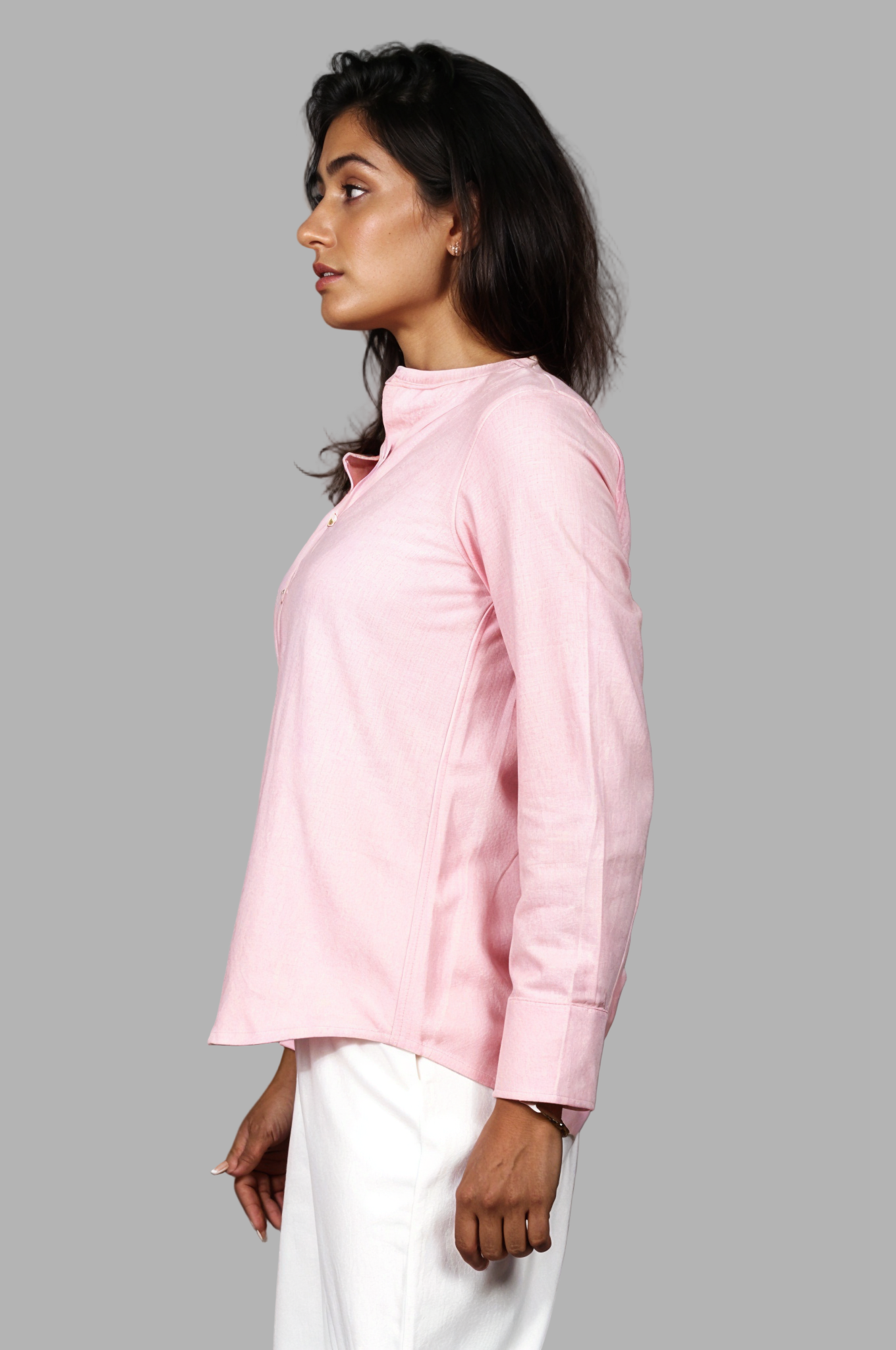 Woman wearing a fullblank branded pink full-sleeves shirt called ORA-A with a plain background