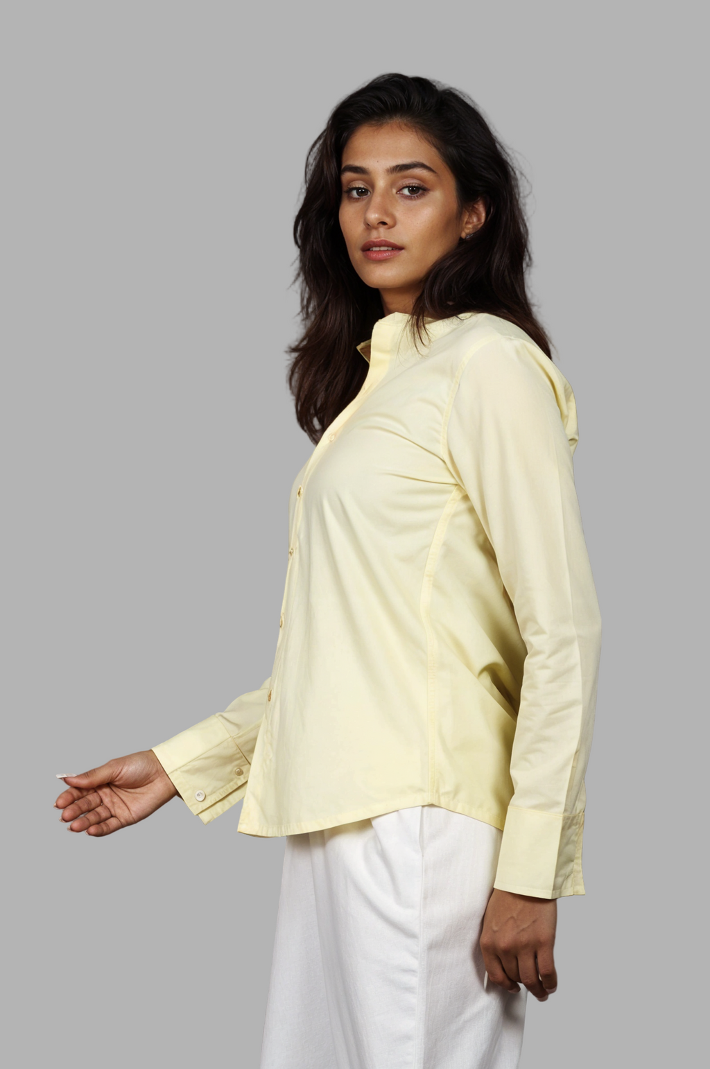 Woman wearing a fullblank branded light yellow full-sleeves shirt called ORA-B with a plain background