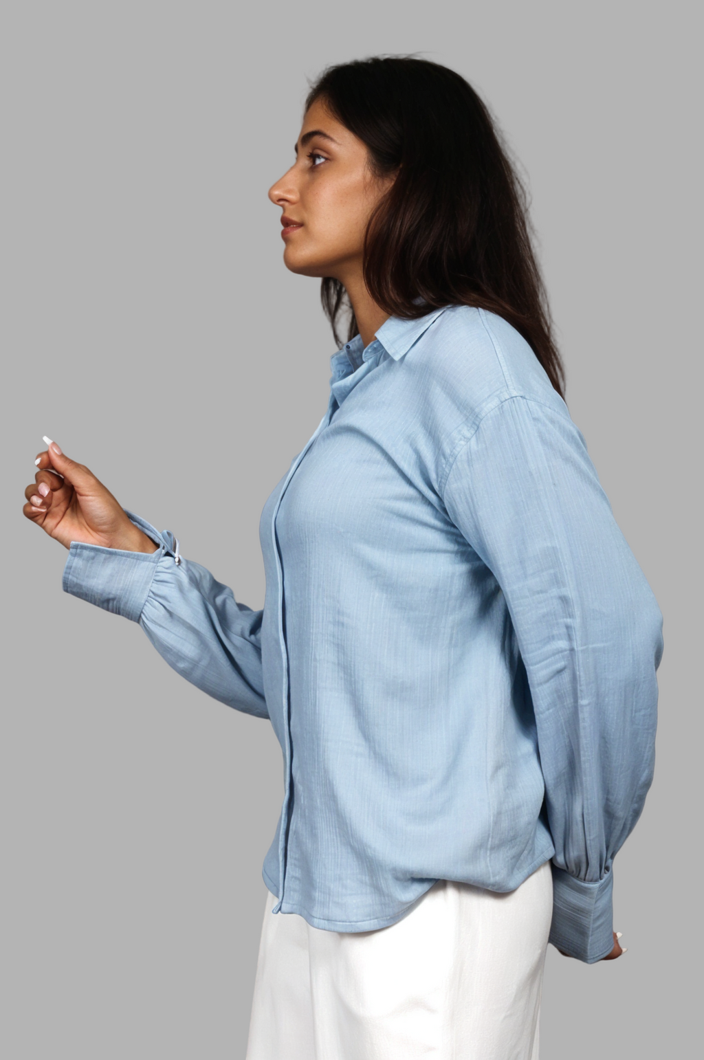 Woman wearing a fullblank branded light blue shirt called PEARL-B with a plain background