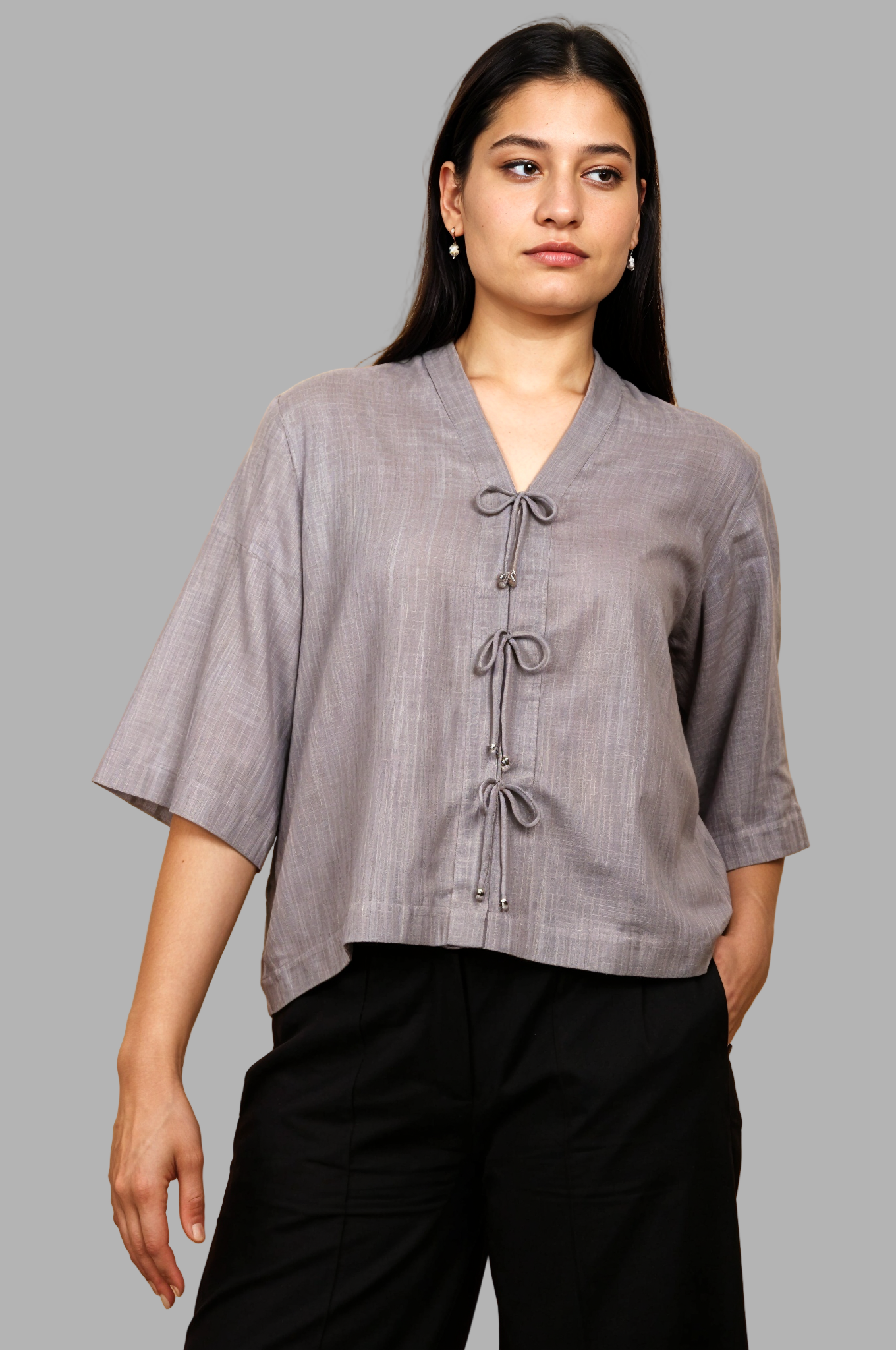 Woman wearing a fullblank branded gray top called RIVA-A with a plain background