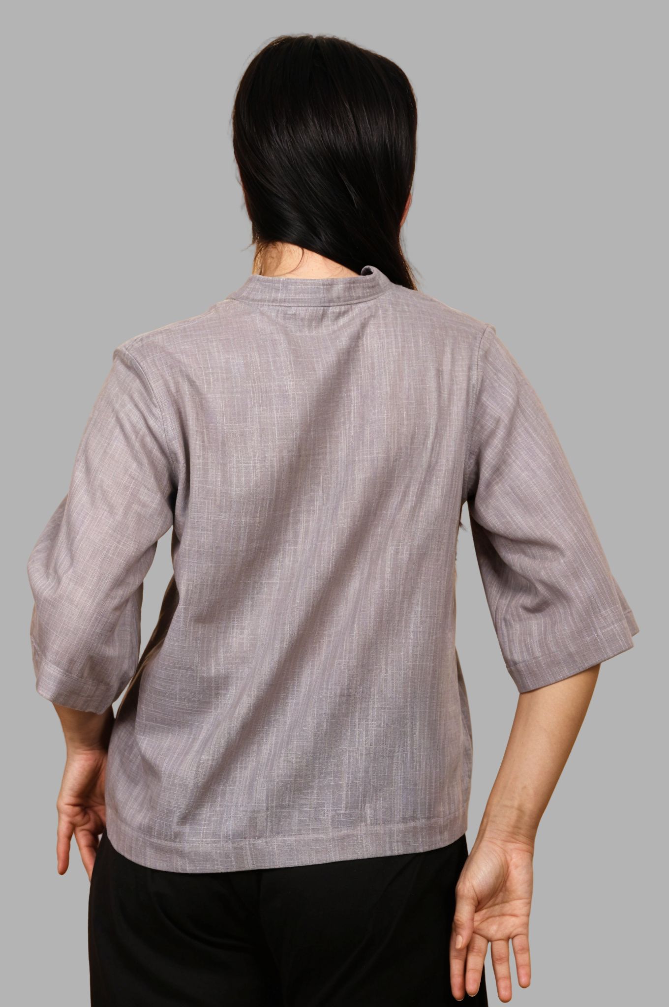Woman wearing a fullblank branded gray top called RIVA-A with a plain background