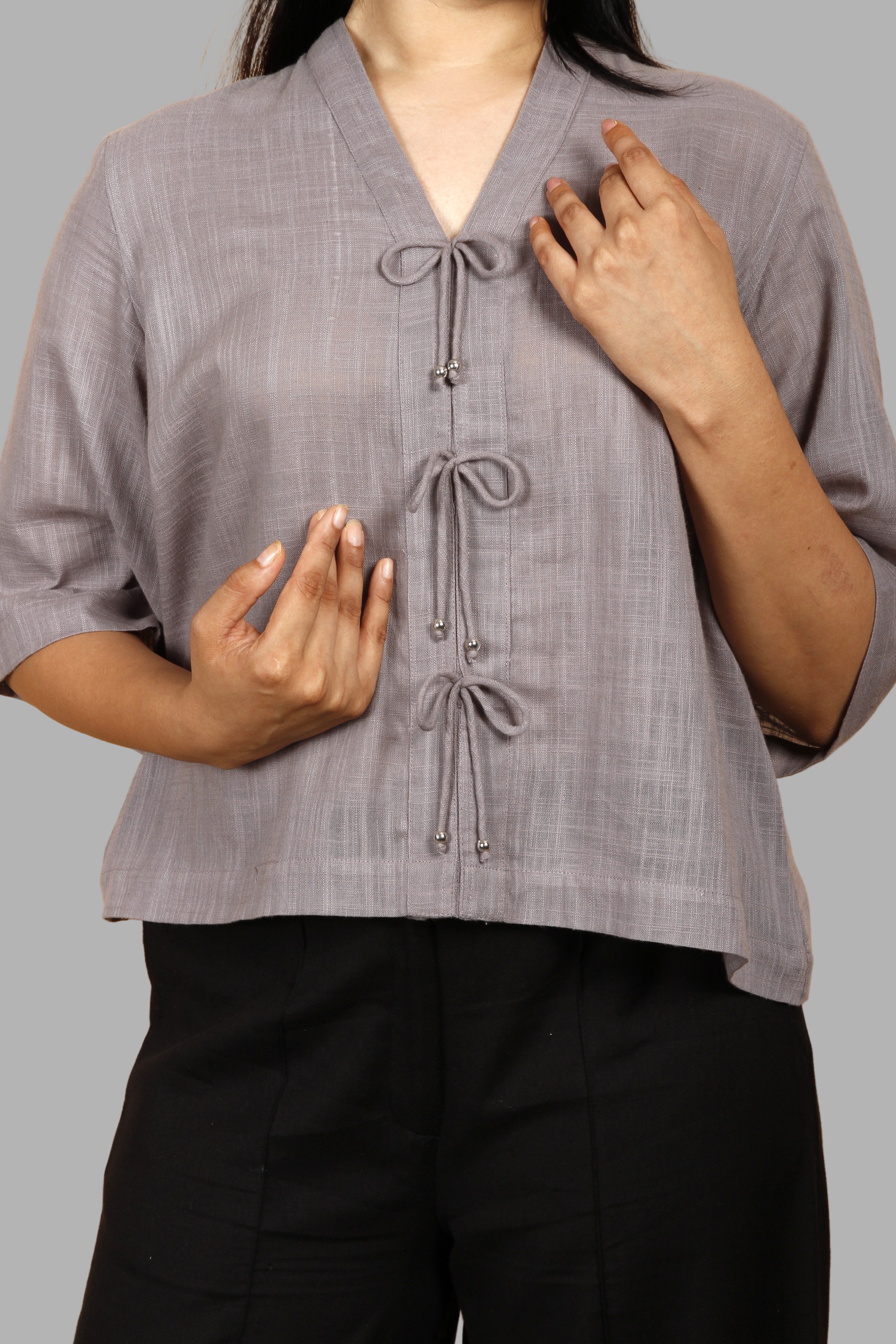 Woman wearing a fullblank branded gray top called RIVA-A with a plain background