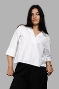 Woman wearing a fullblank branded white shirt called SIRA-A with a plain background