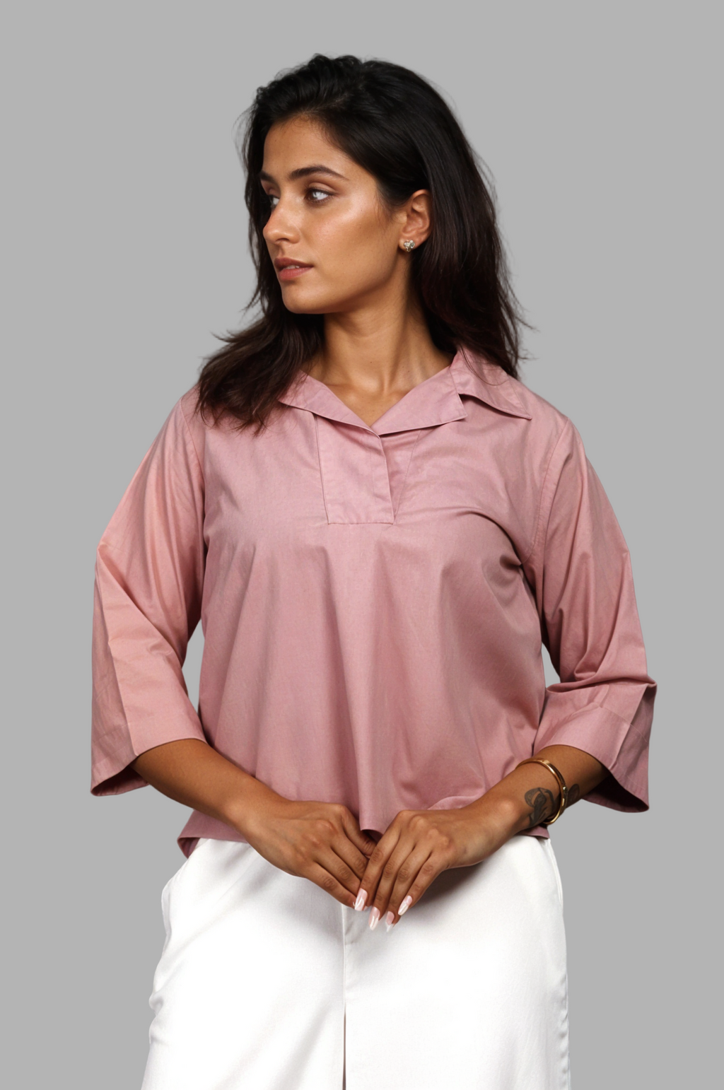 Woman wearing a fullblank branded pink shirt called SIRA-B with a plain background