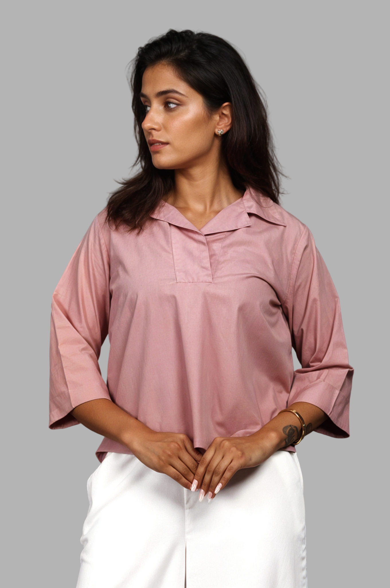 Woman wearing a fullblank branded pink shirt called SIRA-B with a plain background