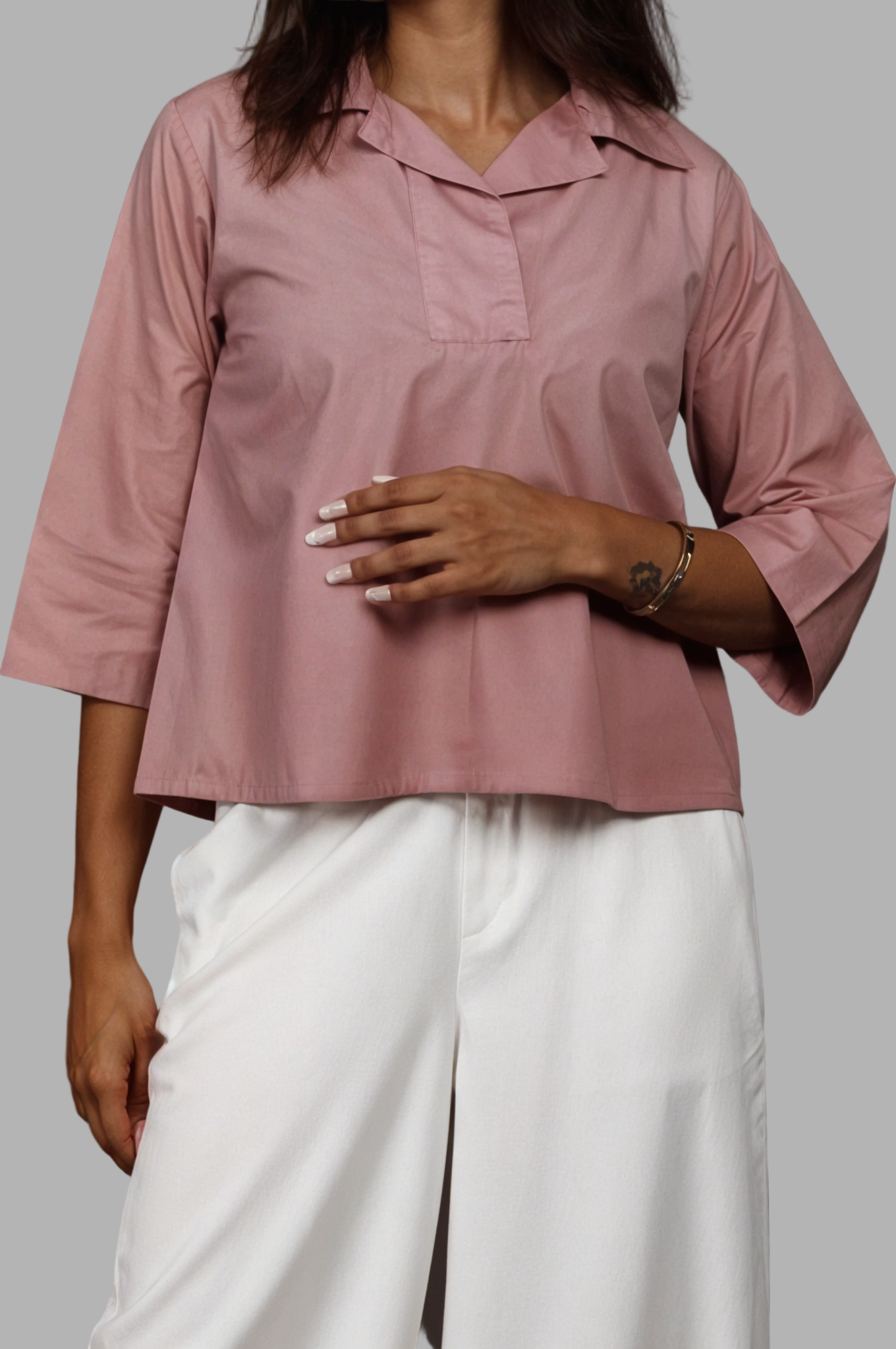 Woman wearing a fullblank branded white shirt called SIRA-A with a plain background