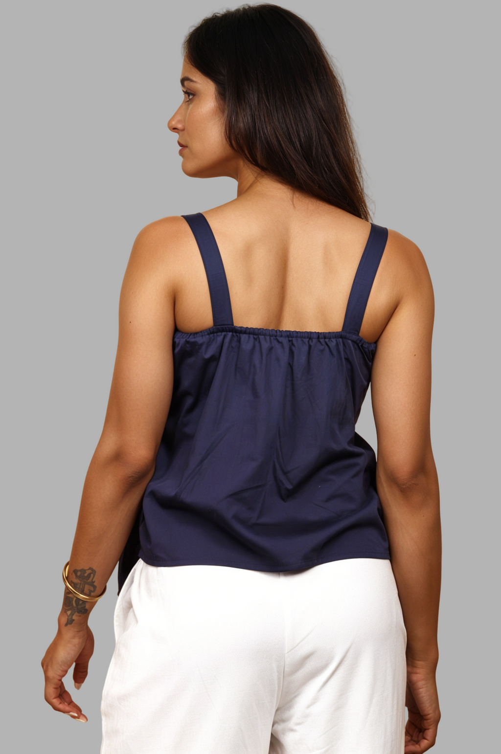 Woman wearing a fullblank branded navy blue top with a bow detail called TWIXY-A with a plain background