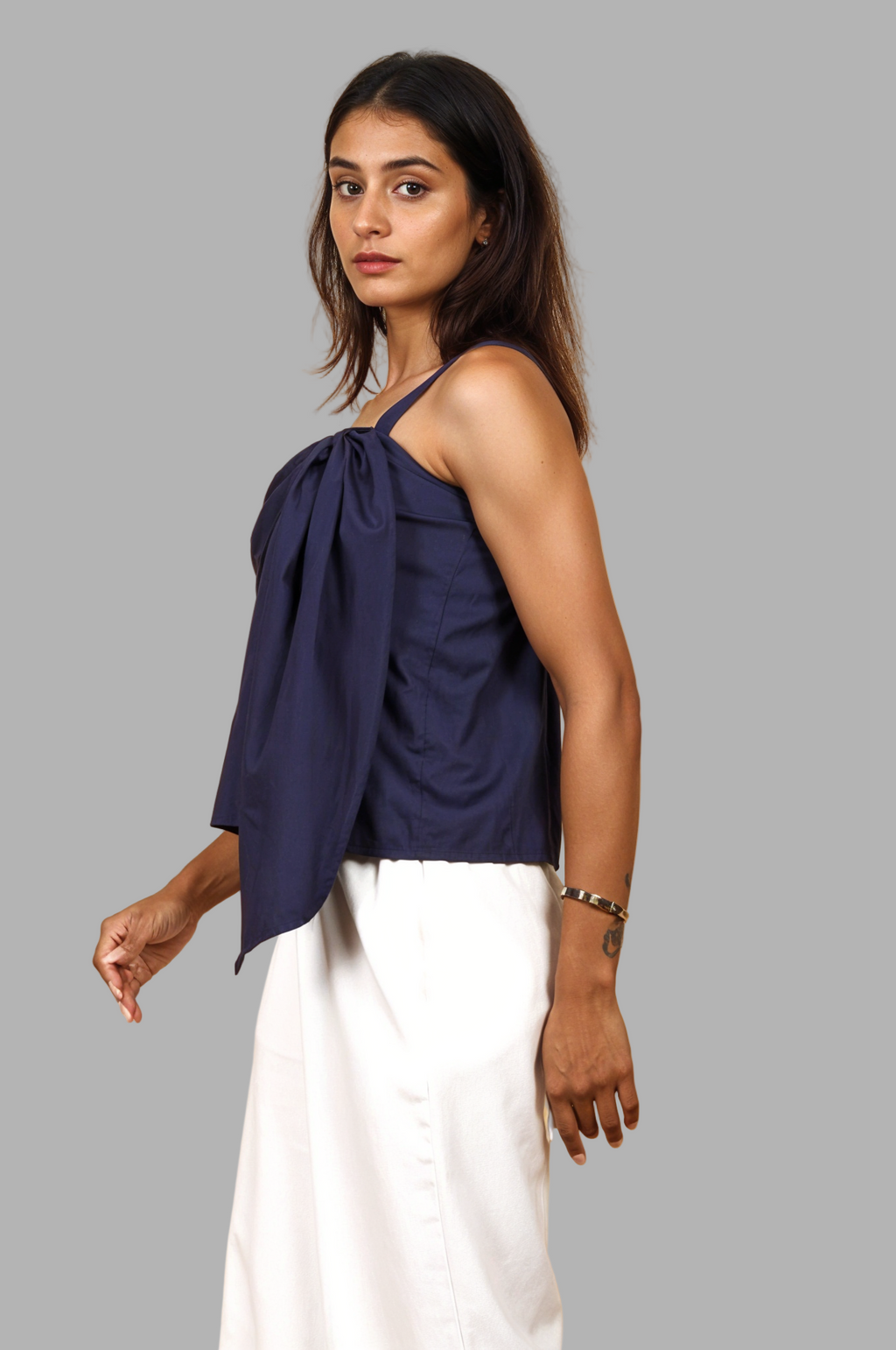 Woman wearing a fullblank branded navy blue top with a bow detail called TWIXY-A with a plain background