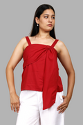 Woman wearing a fullblank branded red top with a bow detail called TWIXY-B with a plain background