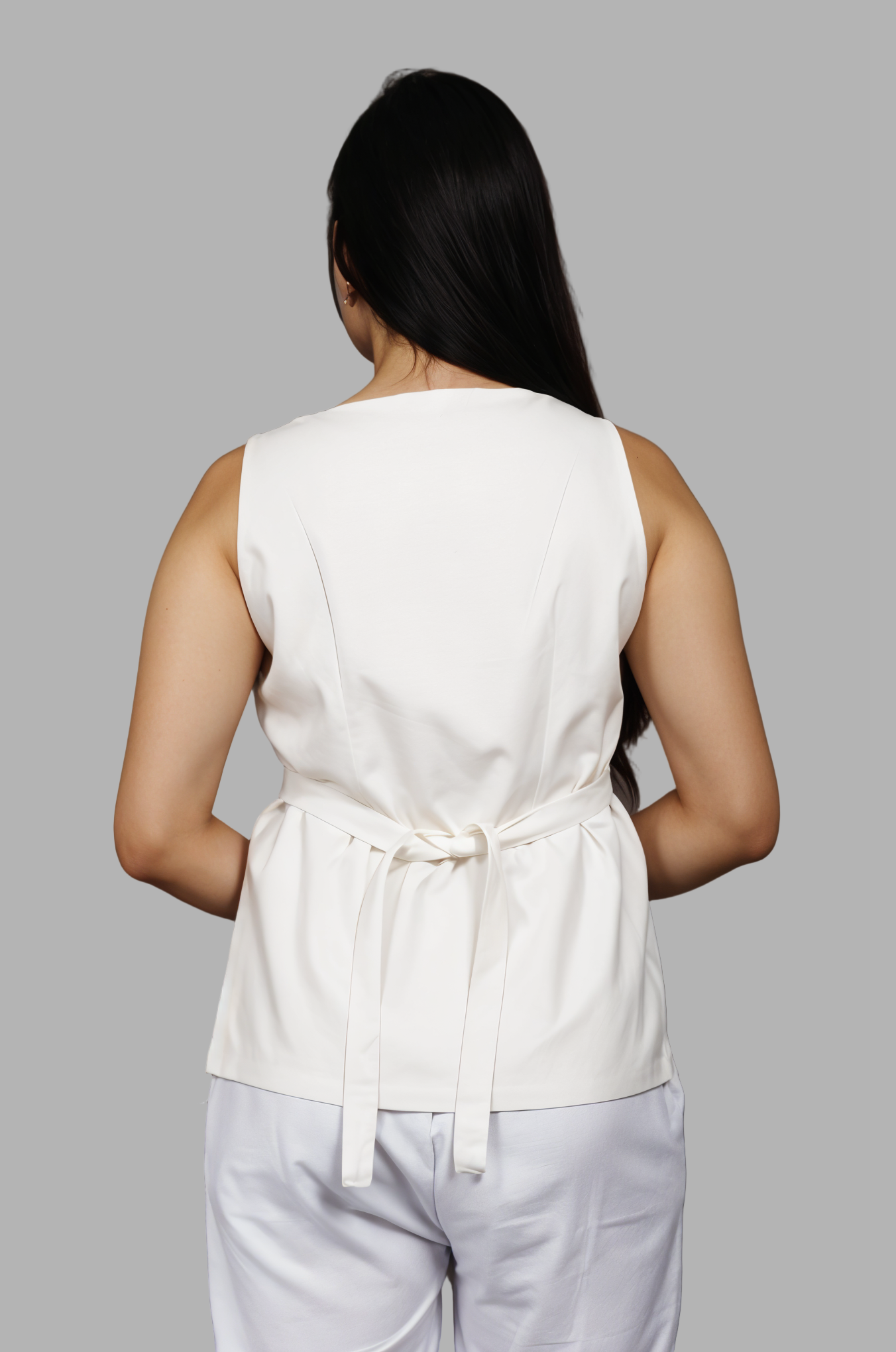 Woman wearing a fullblank branded white vest called ZENA-A with a plain background