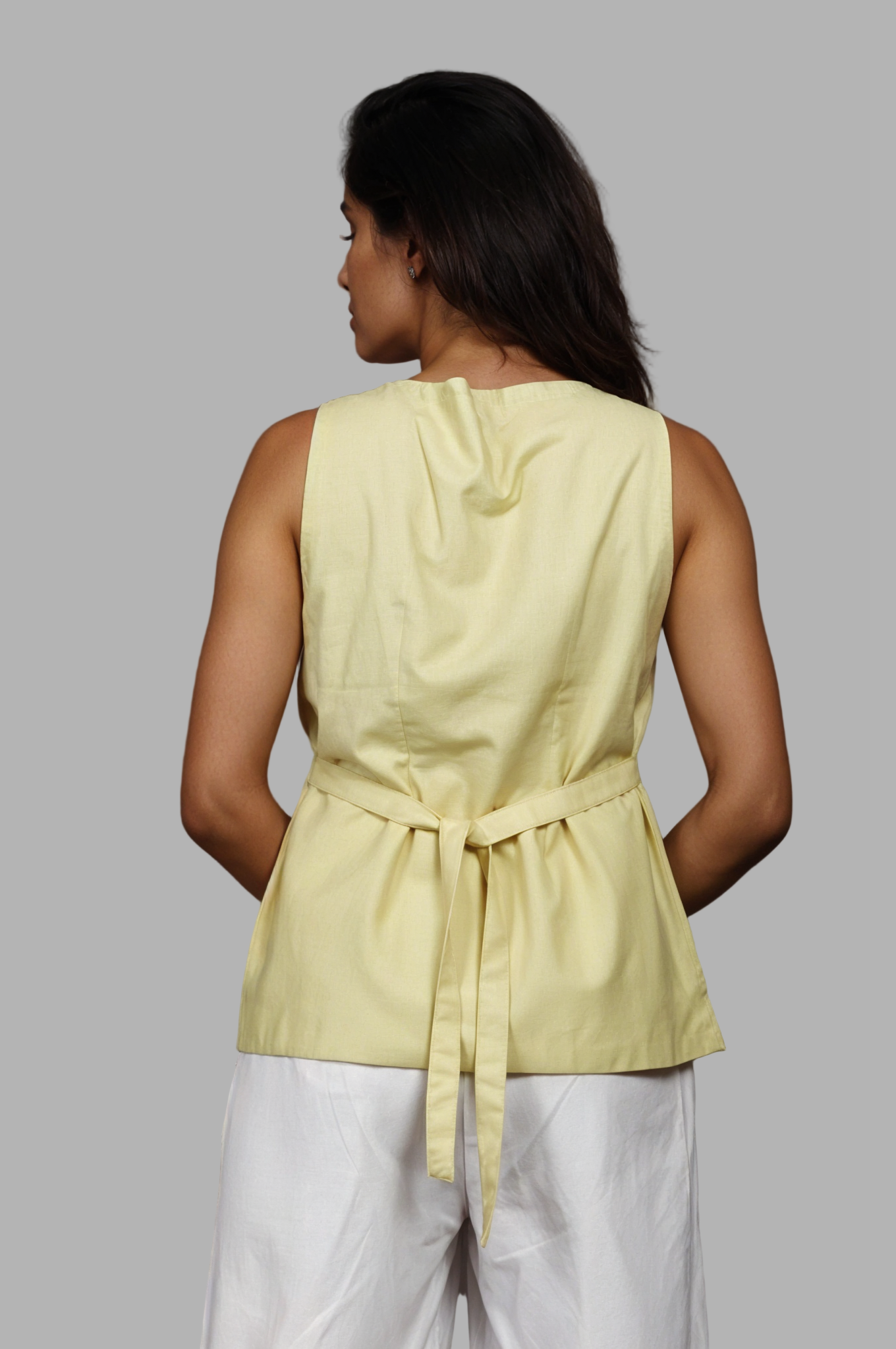 Woman wearing a fullblank branded pistachio vest called ZENA-B with a plain background